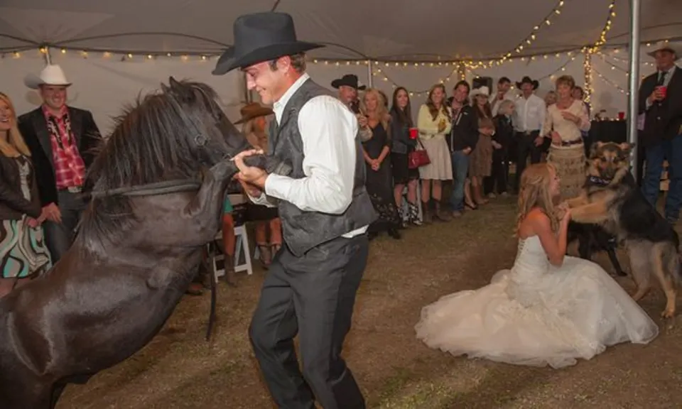 The couple riding horses at their wedding.
