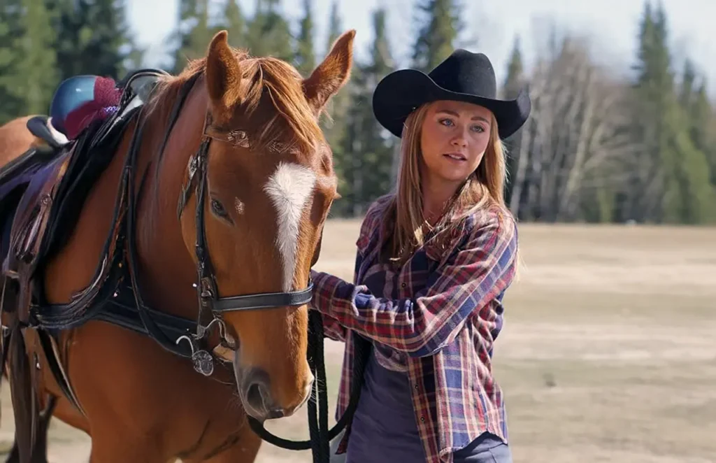Amber Marshall standing with a horse on a grassy Alberta ranch