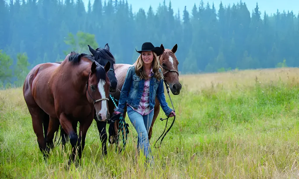 Amber Marshall standing beside her horse, both looking at the camera