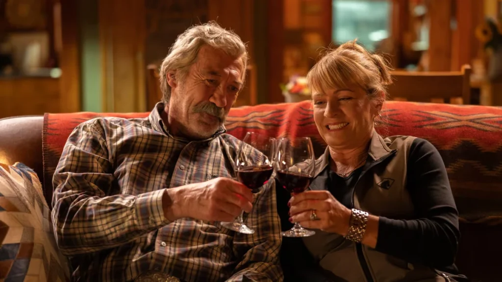 Shaun Johnston as Jack Bartlett and Jessica Steen as Lisa Stillman toast on a couch in Heartland