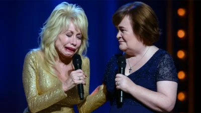 Dolly Parton breaks down in tears while Susan Boyle holds her hand during an emotional duet on stage.
