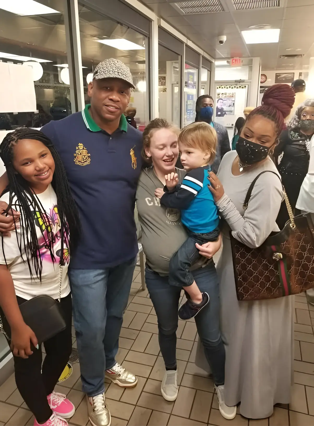 Pregnant waitress Hannah Hill smiling with Bishop Phelps, her son, and his family at Waffle House